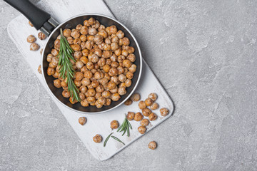 Roasted salty and spicy chickpeas in frying pan with rosemary