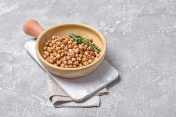 Roasted salty and spicy chickpeas with rosemary in clay baking dish