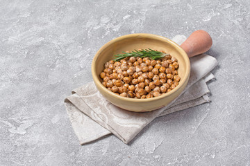 Roasted salty and spicy chickpeas with rosemary in clay baking dish