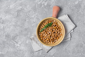 Roasted salty and spicy chickpeas with rosemary in clay baking dish