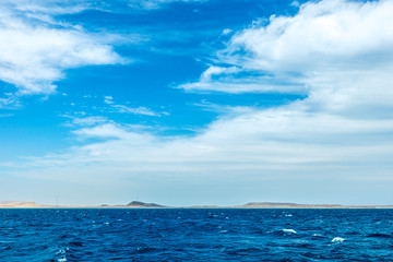 minimalistic seascape, blue sea and sky with white clouds on the whole frame