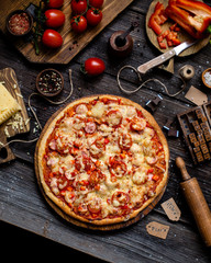 Overhead shot of yummy pizza on rustic dark table