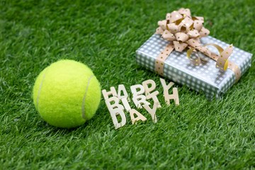 Naklejka premium Happy Birthday to Tennis Player with gifts on green grass