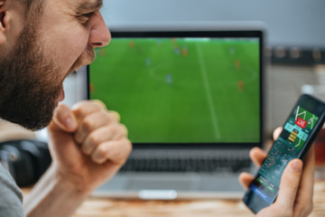 Man celebrating victory after making bets at bookmaker website