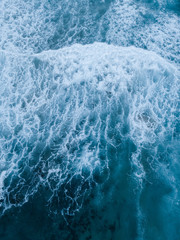 Top down view of wave with white breaking foam.