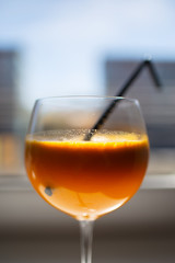 Glass of orange juice over window background.