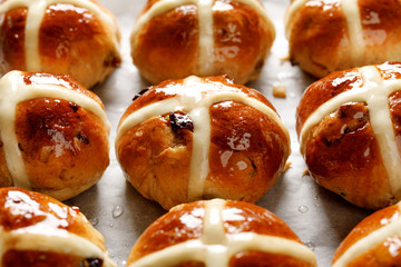 Hot cross buns, freshly baked hot cross buns on white parchment paper, close-up. Traditional easter...