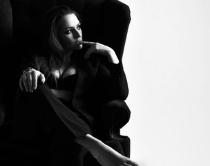 Close up portrait of young beautiful woman sitting in sexy spring jacket and underwear in classic armchair.