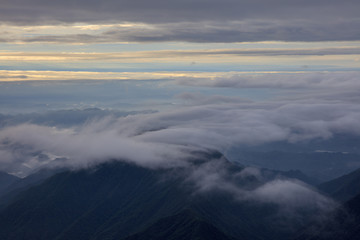 Abstract photograph above the clouds, sea of clouds effect, flying through the sky, aerial view, white puffy clouds and blue sky. Low pressure front atmospheric effect, cloudscape, cloudy weather