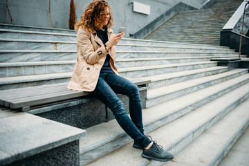 Happy young woman wearing beige trench coat