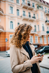 Young woman wearing beige coat and hoodie