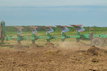 Agricultural tractor plows the land