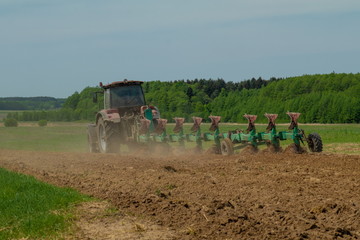 Agricultural tractor plows the land
