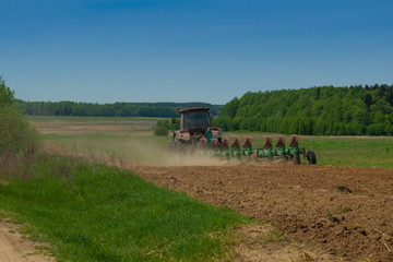 Agricultural tractor plows the land