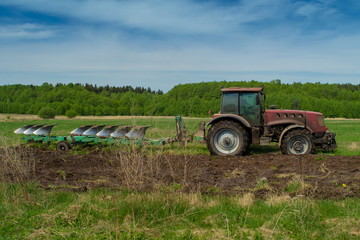 Agricultural tractor plows the land