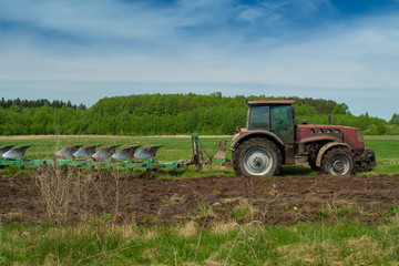 Agricultural tractor plows the land