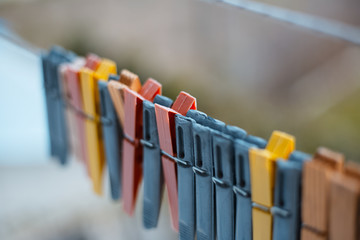 Colorful clothespins outdoor, on the rope over blur background.