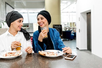 Two Arab women have lunch in a cafe