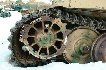 Old battle tank 2nd World War in the snow under the trees.
