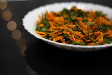 Salad in white plate on black background.