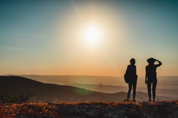 Two female hikers with backpacks at the mountain top