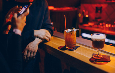 Woman with taking photo of cocktail  from bar counter in nightclub Sweet juicy Cocktail drink beverage on a bar counter stylish edit . design people and luxury concept service barman in nightclub