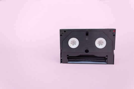 Old vhs video cassette isolated on pink background, Copy space