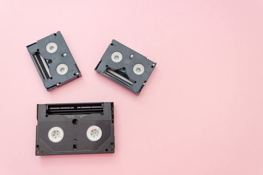 Old VHS videotapes, retro concept. Video cassette on a pink background