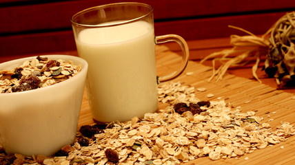 View of bowl of muesli with milk. Healthy breakfast concept with oat on oat flakes background