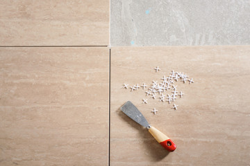 Laying the ceramic tile on the floor. Close up macro shot. Home renovation and building new house...