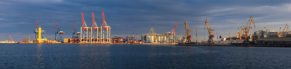 Loading grain to the ship in the port. Panoramic view of the ship, cranes, and other...