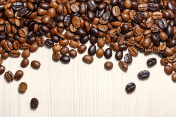 Coffee beans on a light wooden table