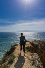 Young attractive woman walking towards ocean horizon in Portugal