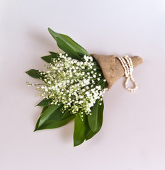 Bouquet of lily of the valley wrapped in a scrim on a white background
