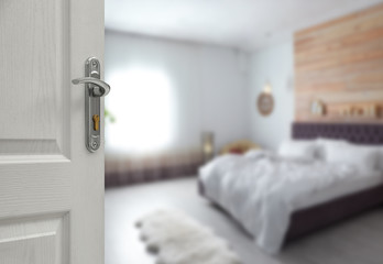 Open wooden door with key hole leading to bedroom