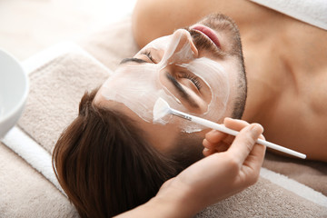 Cosmetologist applying mask on client's face in spa salon - Powered by Adobe