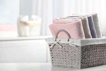 Basket of fresh towels on table. Space for text