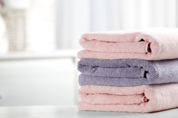 Stack of fresh towels on table. Space for text