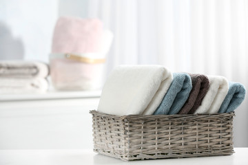 Basket of fresh towels on table. Space for text