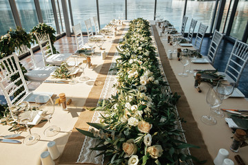 Floral centerpiece on wedding dining table in wedding reception hall.