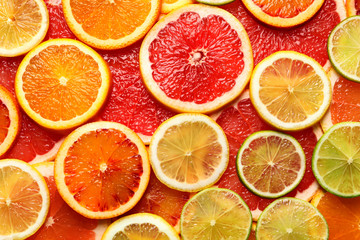 Fototapeta na wymiar Slices of fresh citrus fruits as background, top view