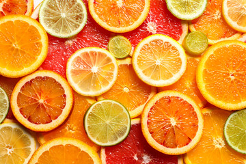 Slices of fresh citrus fruits as background, top view