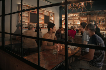 Young friends ordering drinks in a trendy bar at night