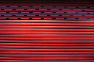 old detailed aged vintage red textured zinc alloy metal roller shutter door, store front exterior...