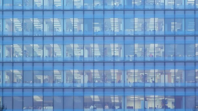Day to night Timelapse of the exterior of an office block at night revealing the daily activity of office workers night themes of routines working late deadlines