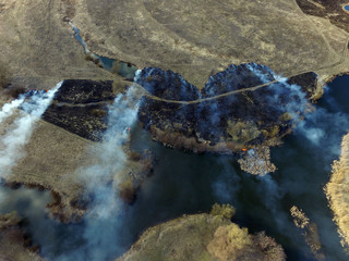 The smoke from the burning of dry grass (drone image).Local residents set fire to the grass...