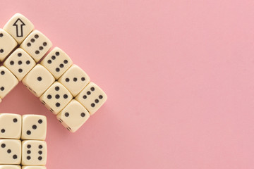 Arrow up. White gaming dices on pink background. victory chance and lucky. Flat lay style, place for text. Top view and Close-up cube. Concept business, gamble and game. Spectacular background pastel.