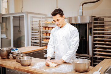Fototapeta na wymiar Baker feeling busy while kneading dough in the morning