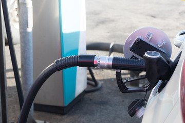 pumping petrol at gas station into vehicle.hand using a fuel nozzle at a gas station.Petrol Gasoline in Cold weather Safe drive concept.