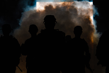 Fototapeta na wymiar silhouette thai soldiers special forces team full uniform walking action through smoke and holding gun on hand